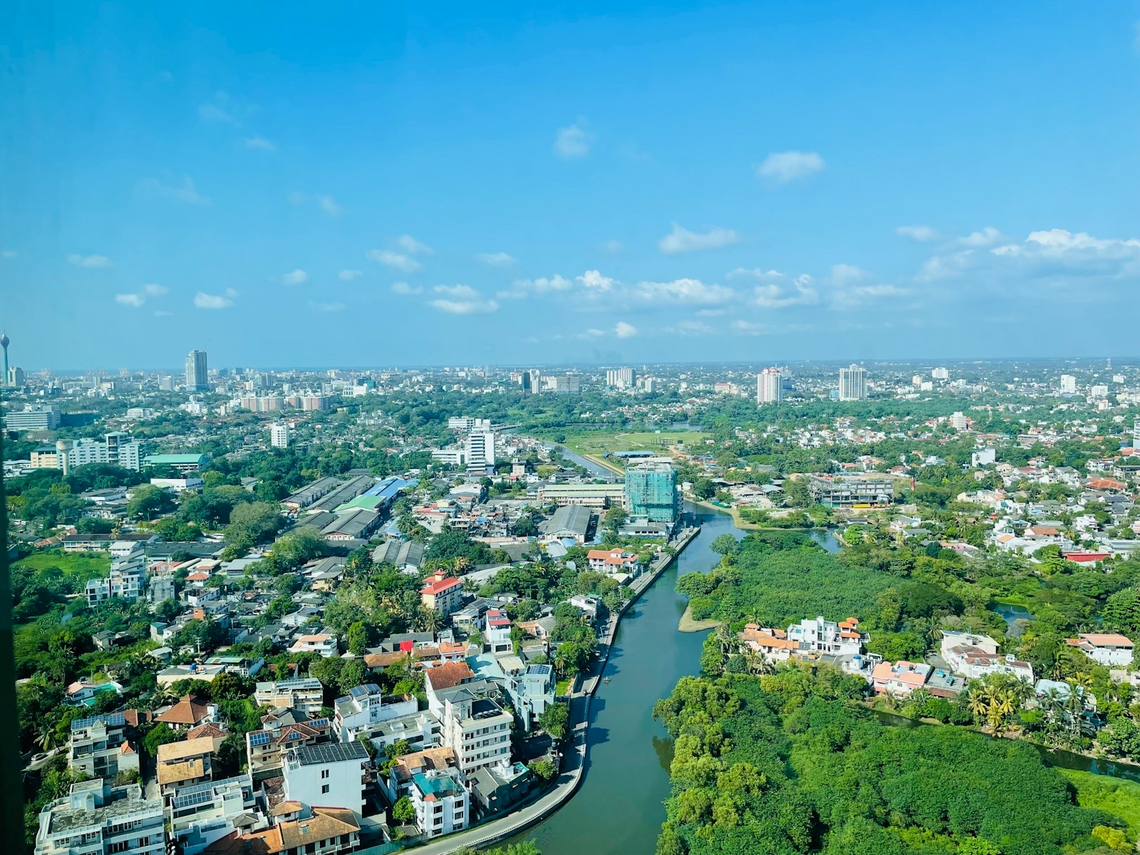 An aerial view of leafy Colombo suburbs with a canal winding through