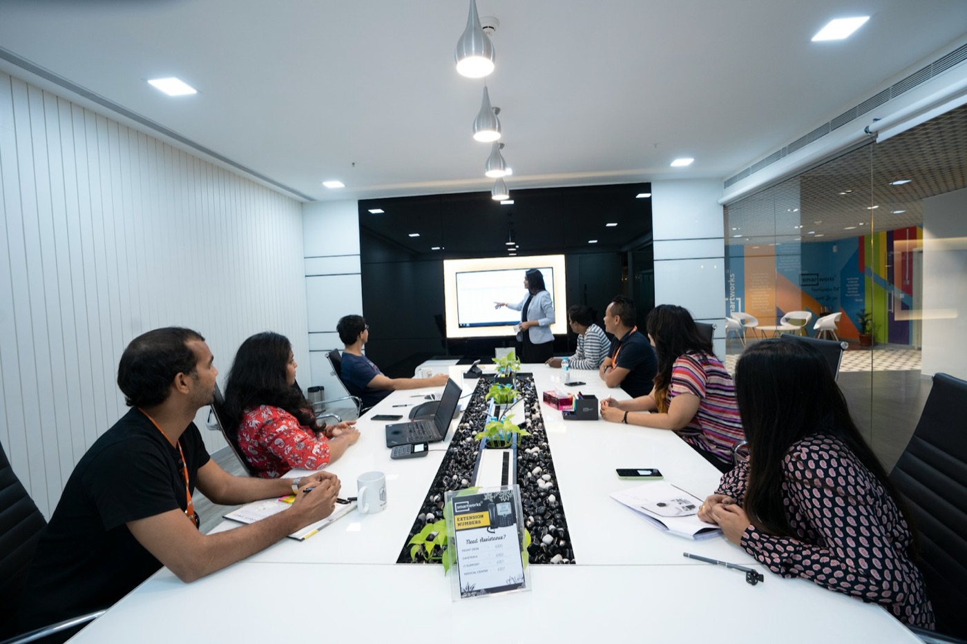 Colleagues working at a long table in a bright New Delhi office